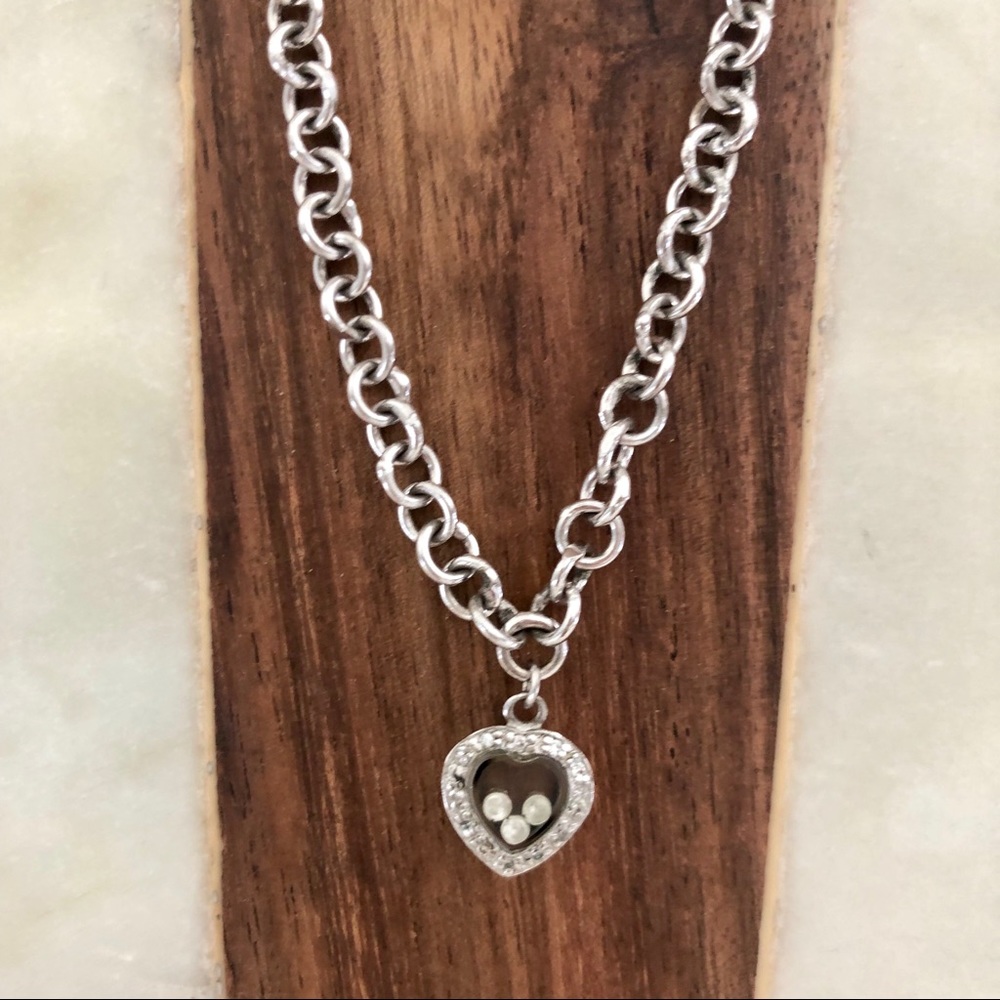 Silver toned heart necklace with crystal beads on the interior of glass chain